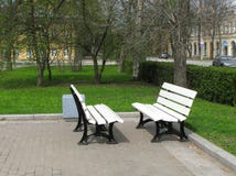 Dos blancos escantillón enfrente de uno a en el parque Bancos fotos de archivo libres de regalías Dos blancos escantillón enfrente de uno a en el parque Bancos fotos de archivo libres de regalías