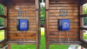 Dos cabinas de teléfono de madera con los teléfonos de pago El concepto por el Año Nuevo a 2018 foto de archivo libre de regalías Dos cabinas de teléfono de madera con los teléfonos de pago El concepto por el Año Nuevo a 2018 foto de archivo libre de regalías