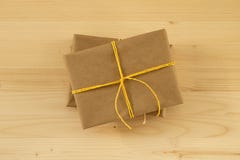 Dos cajas de regalo envueltas del documento del arte y de la cinta amarilla sobre el fondo de madera Fotos de archivo libres de regalías Dos cajas de regalo envueltas del documento del arte y de la cinta amarilla sobre el fondo de madera Fotos de archivo libres de regalías