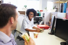 Dos colegas que tienen una hora de la almuerzo en el trabajo fotos de archivo libres de regalías Dos colegas que tienen una hora de la almuerzo en el trabajo fotos de archivo libres de regalías