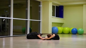 Dos gimnastas art?sticos de las hermanas lindas delgadas de las muchachas en ropa de deportes negra hacer calentamiento en gimnas Dos gimnastas art?sticos de las hermanas lindas delgadas de las muchachas en ropa de deportes negra hacer calentamiento en gimnas
