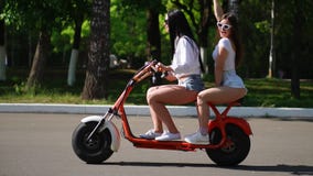 Dos jovenes y los amigos morenos atractivos con el pelo flojo en dril de algodón corto pone en cortocircuito montar una motocicle almacen de metraje de vídeo Dos jovenes y los amigos morenos atractivos con el pelo flojo en dril de algodón corto pone en cortocircuito montar una motocicle almacen de metraje de vídeo