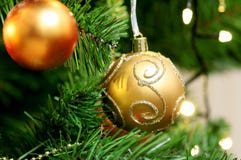 Dos juguetes anaranjados deautiful de la Navidad que cuelgan en el árbol de navidad adornado con las chispas con un modelo del la fotos de archivo libres de regalías Dos juguetes anaranjados deautiful de la Navidad que cuelgan en el árbol de navidad adornado con las chispas con un modelo del la fotos de archivo libres de regalías