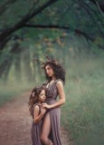 Dos muchachas bajo la forma de abrazo de los ciervos y cerrarse los ojos, faunos en vestidos marrones largos, un recorte revelan imágenes de archivo libres de regalías Dos muchachas bajo la forma de abrazo de los ciervos y cerrarse los ojos, faunos en vestidos marrones largos, un recorte revelan imágenes de archivo libres de regalías