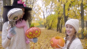 Dos muchachas que celebran Halloween con el esqueleto, la linterna del ` del enchufe o y el sombrero de la bruja almacen de video Dos muchachas que celebran Halloween con el esqueleto, la linterna del ` del enchufe o y el sombrero de la bruja almacen de video