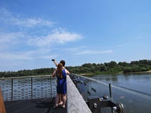 Dos muchachas que tiran a Selfie representan mientras que se colocan en una plataforma de visión sobre el río Vistula en Varsovia fotos de archivo Dos muchachas que tiran a Selfie representan mientras que se colocan en una plataforma de visión sobre el río Vistula en Varsovia fotos de archivo