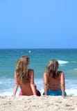 Dos mujeres atractivas jovenes que se enfrían en el sol en día de fiesta o el VAC foto de archivo libre de regalías Dos mujeres atractivas jovenes que se enfrían en el sol en día de fiesta o el VAC foto de archivo libre de regalías