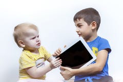 Dos niños pelean, debido a la tableta, el conflicto de los niños imágenes de archivo libres de regalías Dos niños pelean, debido a la tableta, el conflicto de los niños imágenes de archivo libres de regalías