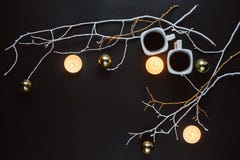 Dos tazas de café, de ramas, de velas y de juguetes de la Navidad en un fondo oscuro fotografía de archivo Dos tazas de café, de ramas, de velas y de juguetes de la Navidad en un fondo oscuro fotografía de archivo