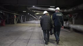Dos trabajadores van en f?brica Ingenieros en pasillo de la producci?n almacen de video Dos trabajadores van en f?brica Ingenieros en pasillo de la producci?n almacen de video