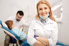 Dosyć pomyślny pediatryczny dentysta pozuje w jej biurze obrazy royalty free Dosyć pomyślny pediatryczny dentysta pozuje w jej biurze obrazy royalty free