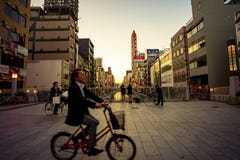 Dotonbori Osaka Japón - la bicicleta no identificada del montar a caballo del hombre november6,2018 que pasa el puente del dotonb fotografía de archivo libre de regalías Dotonbori Osaka Japón - la bicicleta no identificada del montar a caballo del hombre november6,2018 que pasa el puente del dotonb fotografía de archivo libre de regalías