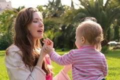 Dottersmink med läppstift till mamman lyckligt älska för familj E royaltyfri fotografi Dottersmink med läppstift till mamman lyckligt älska för familj E royaltyfri fotografi