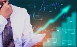 Double exposure - businessman holding a tablet in hand,background an arrow symbol and stock chart,With credit card icon,Concept of stock images Double exposure - businessman holding a tablet in hand,background an arrow symbol and stock chart,With credit card icon,Concept of stock images
