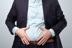 Douleur abdominale homme dans le costume tenant son estomac photo stock Douleur abdominale homme dans le costume tenant son estomac photo stock