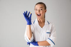 Doutor bonito do cosmetologist da jovem mulher sobre a vitamina cinzenta do comprimido da terra arrendada do fundo da parede imagem de stock royalty free Doutor bonito do cosmetologist da jovem mulher sobre a vitamina cinzenta do comprimido da terra arrendada do fundo da parede imagem de stock royalty free