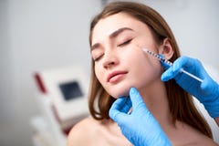 Doutor do esteticista com a seringa botulinum da toxina que faz a inje??o a para remover os p?s de corvo Volume do mordente para imagem de stock royalty free Doutor do esteticista com a seringa botulinum da toxina que faz a inje??o a para remover os p?s de corvo Volume do mordente para imagem de stock royalty free