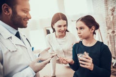Doutor indiano que vê pacientes no escritório O doutor está dando comprimidos e água à filha fotografia de stock royalty free Doutor indiano que vê pacientes no escritório O doutor está dando comprimidos e água à filha fotografia de stock royalty free