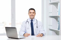 Doutor masculino de sorriso com o portátil no escritório médico foto de stock royalty free Doutor masculino de sorriso com o portátil no escritório médico foto de stock royalty free