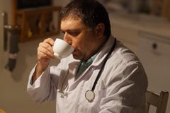 Doutor masculino que relaxa em casa imagens de stock royalty free Doutor masculino que relaxa em casa imagens de stock royalty free