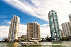 Downtown Miami Along Biscayne Bay With Condos And Office Buildings, Yacht Sailing In The Bay Stock Photo Downtown Miami Along Biscayne Bay With Condos And Office Buildings, Yacht Sailing In The Bay Stock Photo