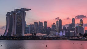 Downtown skyline of Singapore as viewed from across the water from The Garden East day to night timelapse. Singapore.