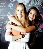 Dra tillbaka till skolan efter sommarsemestrar, tv? ton?riga flickor i klassrum med svart tavla som tillsammans m?las royaltyfri foto Dra tillbaka till skolan efter sommarsemestrar, tv? ton?riga flickor i klassrum med svart tavla som tillsammans m?las royaltyfri foto