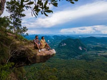 Dragon Crest mountain Krabi Thailand, a Young traveler sits on a rock that overhangs the abyss, with a beautiful. Landscape. Dragon Crest or Khuan Sai at Khao