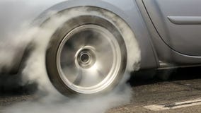 Dragracingauto brennt Gummi weg von seinen Reifen Dragracingauto brennt Gummi weg von seinen Reifen