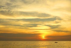 Dramatic colorful sea sunset with sun setting on water lonely boat on horison stock images Dramatic colorful sea sunset with sun setting on water lonely boat on horison stock images