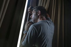Dramatic Light Indoors Portrait Of Young Sad And Depressed Attractive Man Looking Through Home Room Window Thoughtful And Pensive Royalty Free Stock Images Dramatic Light Indoors Portrait Of Young Sad And Depressed Attractive Man Looking Through Home Room Window Thoughtful And Pensive Royalty Free Stock Images