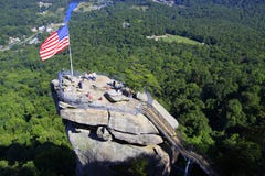 Drapeau américain et touristes à la roche de cheminée en Caroline du Nord, Etats-Unis photo libre de droits Drapeau américain et touristes à la roche de cheminée en Caroline du Nord, Etats-Unis photo libre de droits