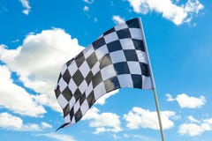 Drapeau à carreaux sur le mât de drapeau avec les nuages blancs sur le fond image stock Drapeau à carreaux sur le mât de drapeau avec les nuages blancs sur le fond image stock