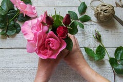 Draufsicht des weiblichen Dekorateurs Rosen auf dem Holztisch vereinbarend lizenzfreies stockfoto Draufsicht des weiblichen Dekorateurs Rosen auf dem Holztisch vereinbarend lizenzfreies stockfoto