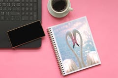 Draufsicht von den Flamingos, die eine Herzform in Bücher mit Smartphone auf Laptop-Computer und Tasse Kaffee auf rosa Hintergrun stockbild Draufsicht von den Flamingos, die eine Herzform in Bücher mit Smartphone auf Laptop-Computer und Tasse Kaffee auf rosa Hintergrun stockbild