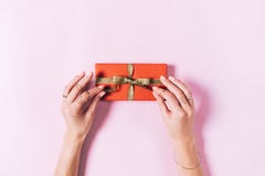 Draufsicht von den weiblichen Händen, die einen Bogen auf einem Kasten mit einem Geschenk binden stockfoto Draufsicht von den weiblichen Händen, die einen Bogen auf einem Kasten mit einem Geschenk binden stockfoto