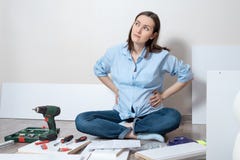 Dreamy pregnant woman sitting on the floor collecting baby furniture, space for text stock images Dreamy pregnant woman sitting on the floor collecting baby furniture, space for text stock images