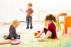 Drei Kinder, die mit Spielwaren spielen lizenzfreies stockbild Drei Kinder, die mit Spielwaren spielen lizenzfreies stockbild
