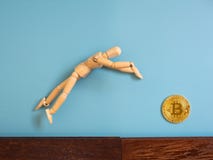 Drewniany kukiełkowy doskakiwanie od drewnianej podłoga w powietrzu łapać bitcoin obraz stock Drewniany kukiełkowy doskakiwanie od drewnianej podłoga w powietrzu łapać bitcoin obraz stock