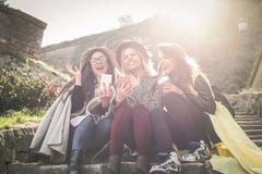 Drie jonge meisjes die op de treden bij het openbare park zitten stock foto Drie jonge meisjes die op de treden bij het openbare park zitten stock foto