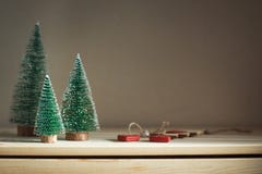 Drie Kerstbomen op een houten opmaker Het comfortabele stilleven van de huiswinter Gestemd, exemplaarruimte stock afbeeldingen Drie Kerstbomen op een houten opmaker Het comfortabele stilleven van de huiswinter Gestemd, exemplaarruimte stock afbeeldingen