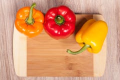 Drie kleuren de peper op houten scherpe achtergrond Gele, oranje en Spaanse pepers Populaire peper in keuken stock fotografie Drie kleuren de peper op houten scherpe achtergrond Gele, oranje en Spaanse pepers Populaire peper in keuken stock fotografie