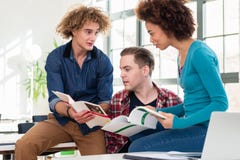 Drie studenten die informatie van twee verschillende handboeken vergelijken royalty-vrije stock foto's Drie studenten die informatie van twee verschillende handboeken vergelijken royalty-vrije stock foto's