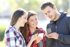 Drie vrienden die houdend hun slimme telefoons spreken royalty-vrije stock afbeelding Drie vrienden die houdend hun slimme telefoons spreken royalty-vrije stock afbeelding
