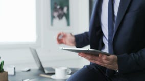 Driking καφές επιχειρηματιών χρησιμοποιώντας μια ταμπλέτα απόθεμα βίντεο Driking καφές επιχειρηματιών χρησιμοποιώντας μια ταμπλέτα απόθεμα βίντεο