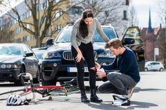 Driver using a sterile bandage to help an injured bicyclist royalty free stock image Driver using a sterile bandage to help an injured bicyclist royalty free stock image