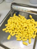 drogue las cápsulas amarillas de las etiquetas en el brillo que cuenta la bandeja en droguería o fotografía de archivo drogue las cápsulas amarillas de las etiquetas en el brillo que cuenta la bandeja en droguería o fotografía de archivo