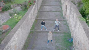 Drohnenschießen von, das drei Freunden tun Spaßtanz in der alten italienischen Stadt ist stock footage Drohnenschießen von, das drei Freunden tun Spaßtanz in der alten italienischen Stadt ist stock footage