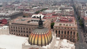Drone camera flying around colorful dome with bird sculpture of Palace of fine arts (Palacio de Bellas Artes) in