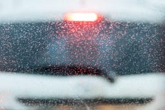 droppar på vindrutan av bilen i asken en suddig vit bil på bakgrund royaltyfri bild droppar på vindrutan av bilen i asken en suddig vit bil på bakgrund royaltyfri bild